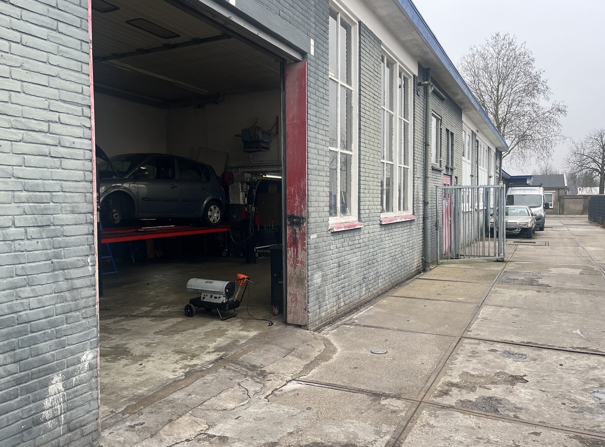De ingang van de werkplaats in het grijze bakstenen gebouw aan de Nijverheidsweg-Noord